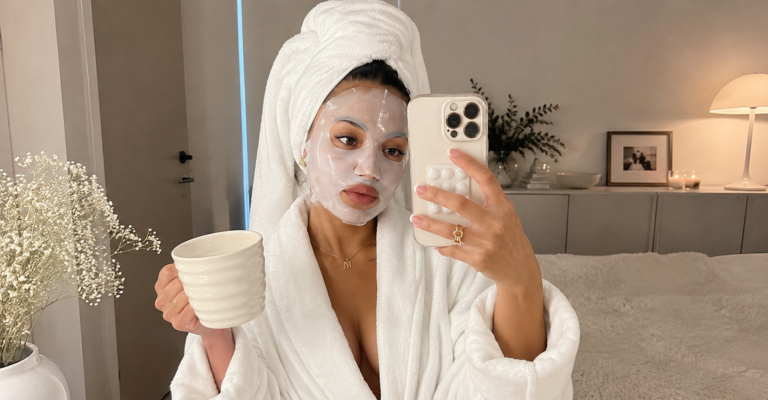 Woman applying sheetmask as part of a minimalist skincare approach with just four simple products